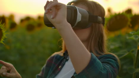 A-young-female-uses-VR-glasses-on-the-field-with-sunflowers-in-sunny-day.-These-are-modern-technologies-in-summer-evening.